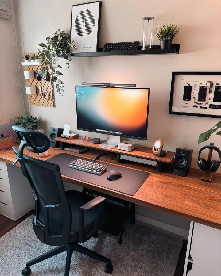 Warm wooden pegboard with white accessories in stylish home office by @lee__desksetup. Cozy and organized workspace setup.