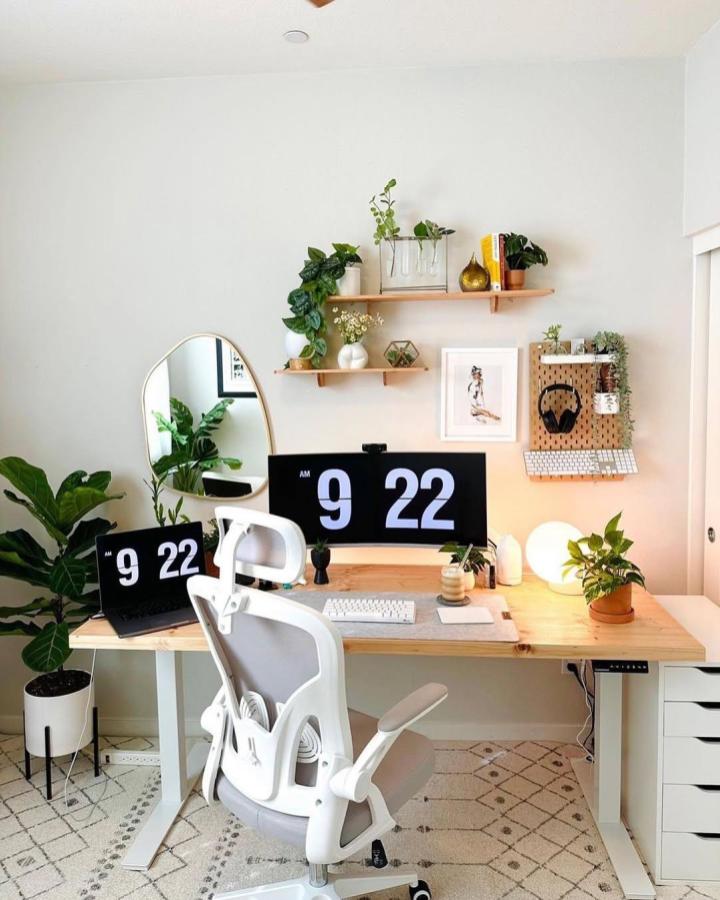 Light wood pegboard with keyboard shelf and plants in a clean white office by @kristenintech showcasing smart workspace organization.