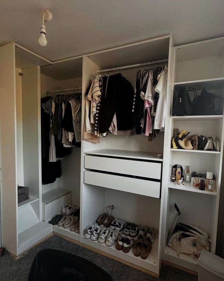 Bright white modular wardrobe with dual hanging rods and open shelving from @no32.reno showing corner storage enhancement.