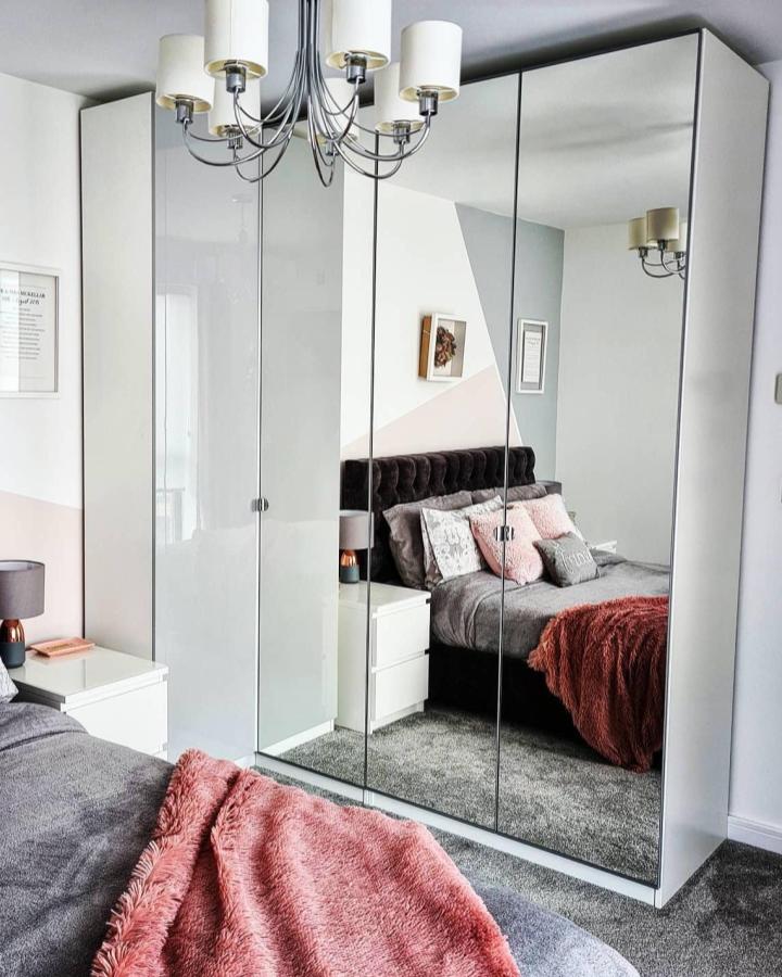 White gloss Ikea Pax corner wardrobe with mirrored doors from @athome_withkerry showcasing ikea pax corner wardrobe ideas reflecting bedroom interior.