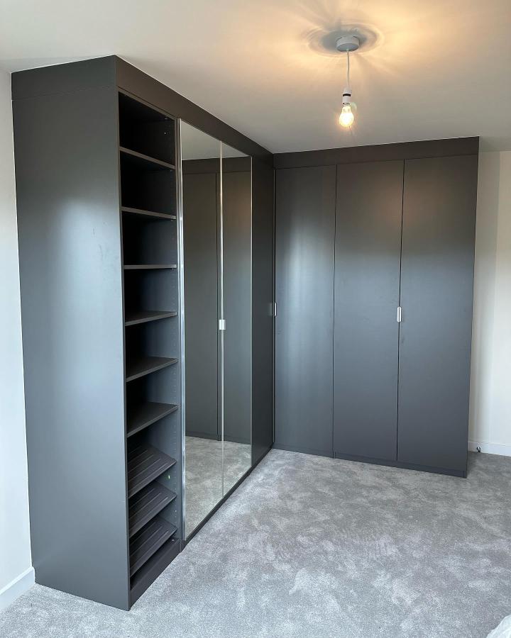 Matte grey corner wardrobe with open shelves and mirrored door by @ikeapaxuk in a cozy bedroom setting. Simple and modern design.