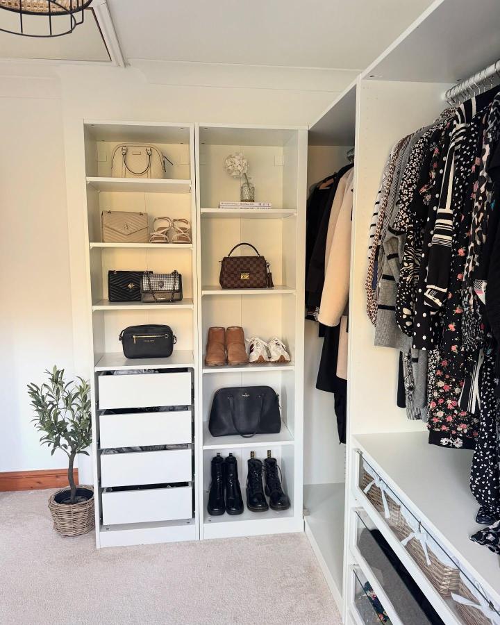 White minimalist corner wardrobe shelves with handbags and boots from @atthemeadows. Bright, organized, and functional storage solution.
