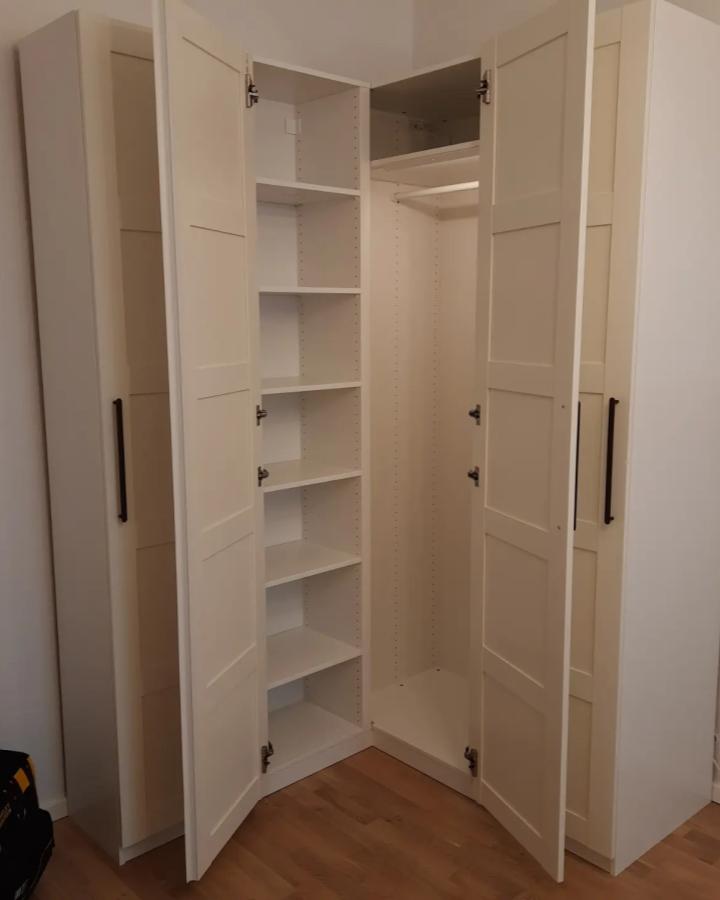 White modular corner wardrobe from @engineercraftsman with adjustable shelves and bifold doors for versatile bedroom storage.
