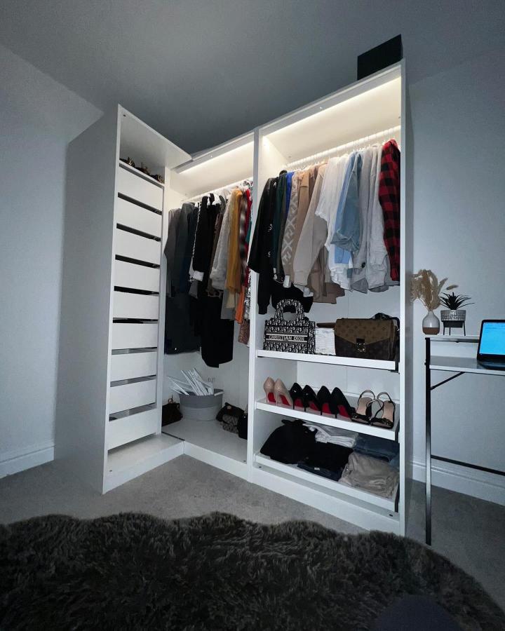 Bright white modular wardrobe with LED lights and open shelves from @flatpackitalex showing smart corner storage solution.