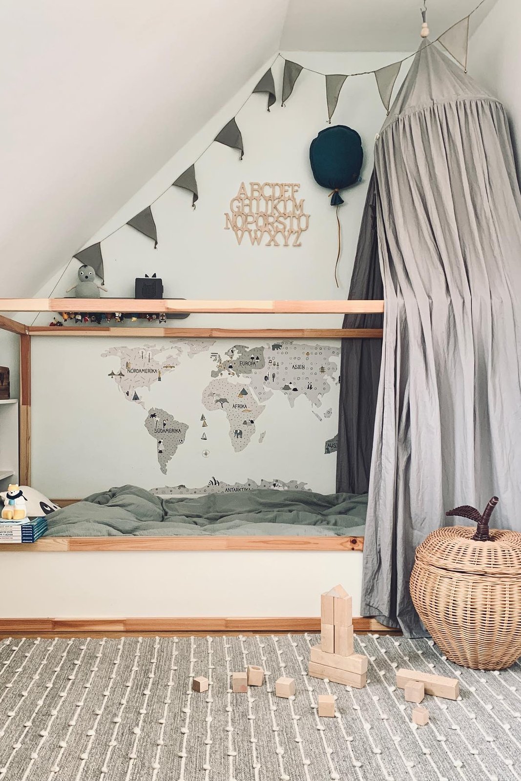 best accessories for ikea kura beds with grey canopy, world map, bunting, and natural wood details