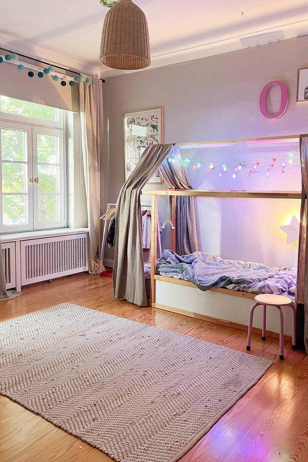 Soft KURA bed canopy with curtains, fairy lights, cozy bedding, rug, and playful bedroom decor