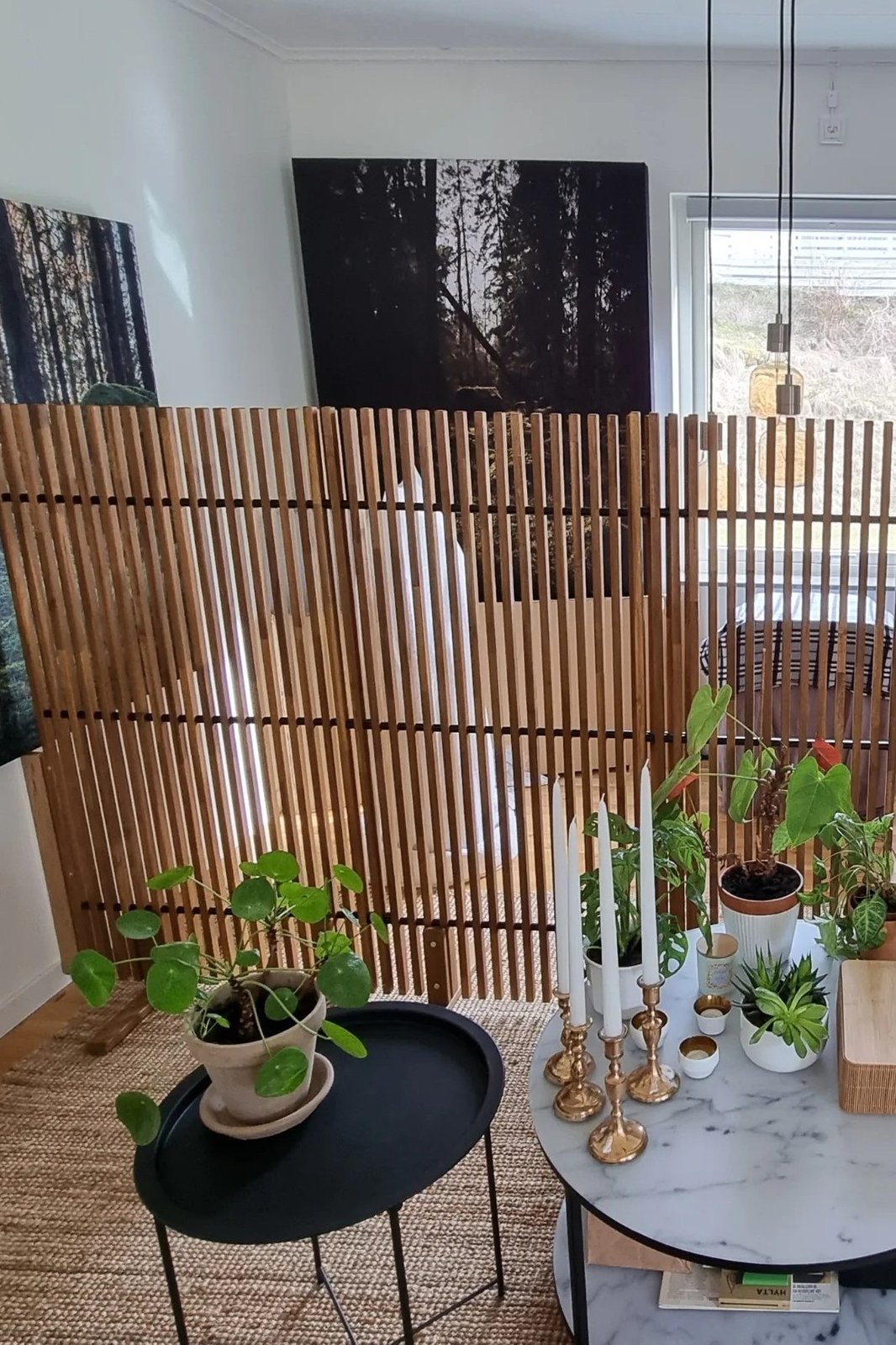 Warm IKEA slatted room divider filtering light beside plants and a cozy dining area