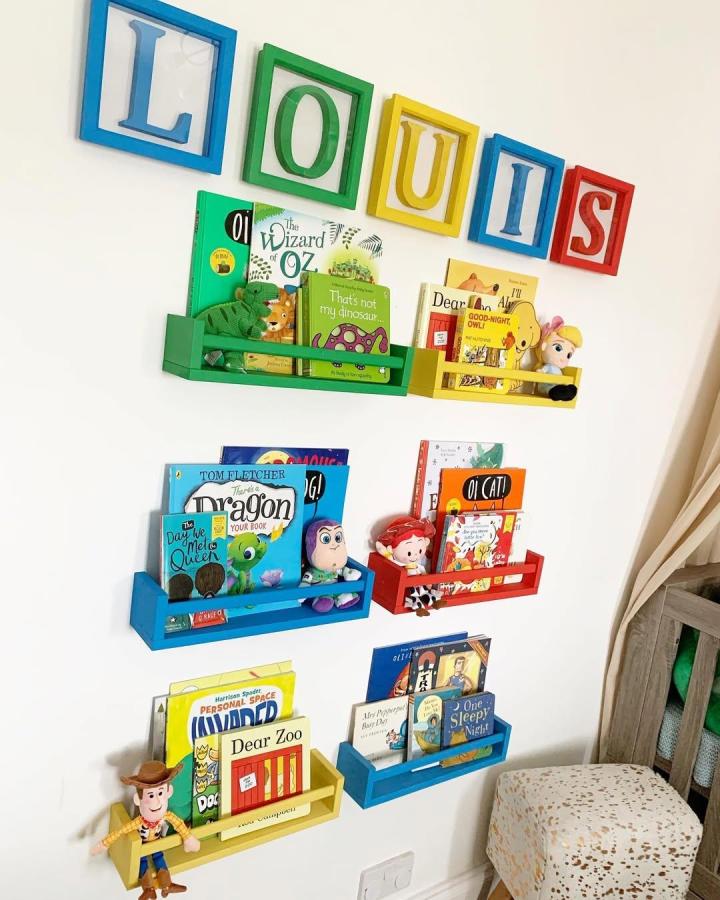 Brightly painted Ikea Bekvam book racks from @jlsummerton. Primary color nursery storage with playful framed letters.