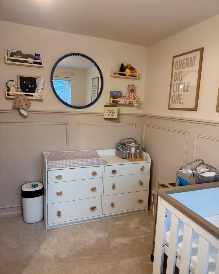 Natural wood Ikea Bekvam spice rack shelves in soft pastel nursery from @maddisonnkennedy. Wall-mounted toy and book storage repurposed creatively.