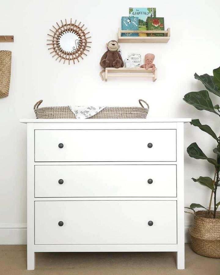 White minimalist Ikea Bekvam dresser with woven basket and light wood shelves from @lets.stay.at.home. Cozy nursery storage with natural accents.
