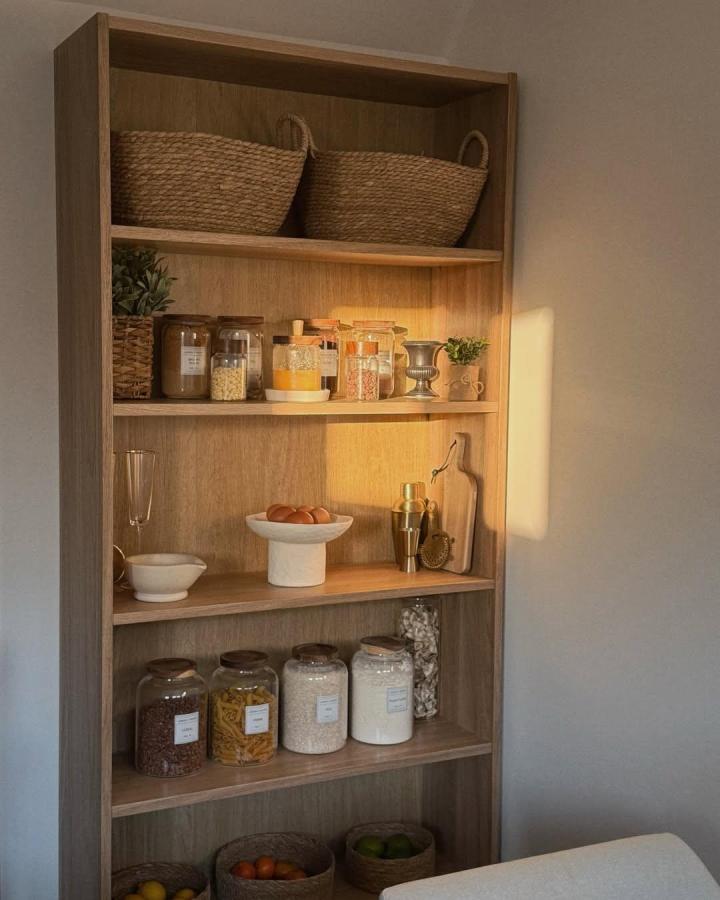 Natural wood pantry shelf with woven baskets and glass jars from @nbhouse23. Warm, simple, and stylish kitchen storage solution.