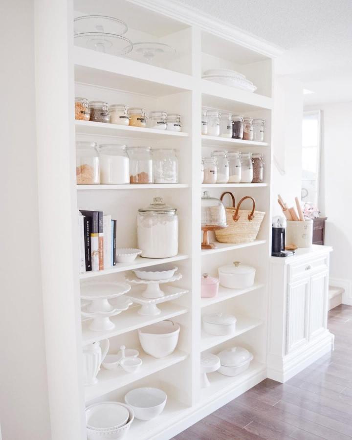 Bright white built-in pantry shelves with glass jars and ceramic dishes by @breakfastatkellies. Elegant storage and organization.