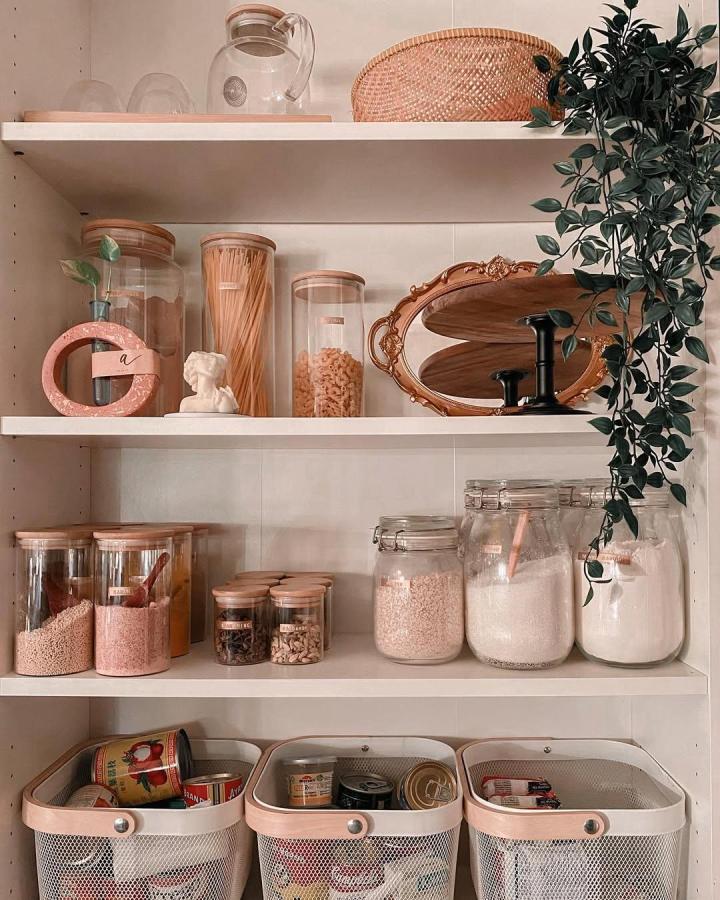Glass jars with wooden lids and white shelves pantry setup from @cosywithrara featuring natural decor and organized food storage.