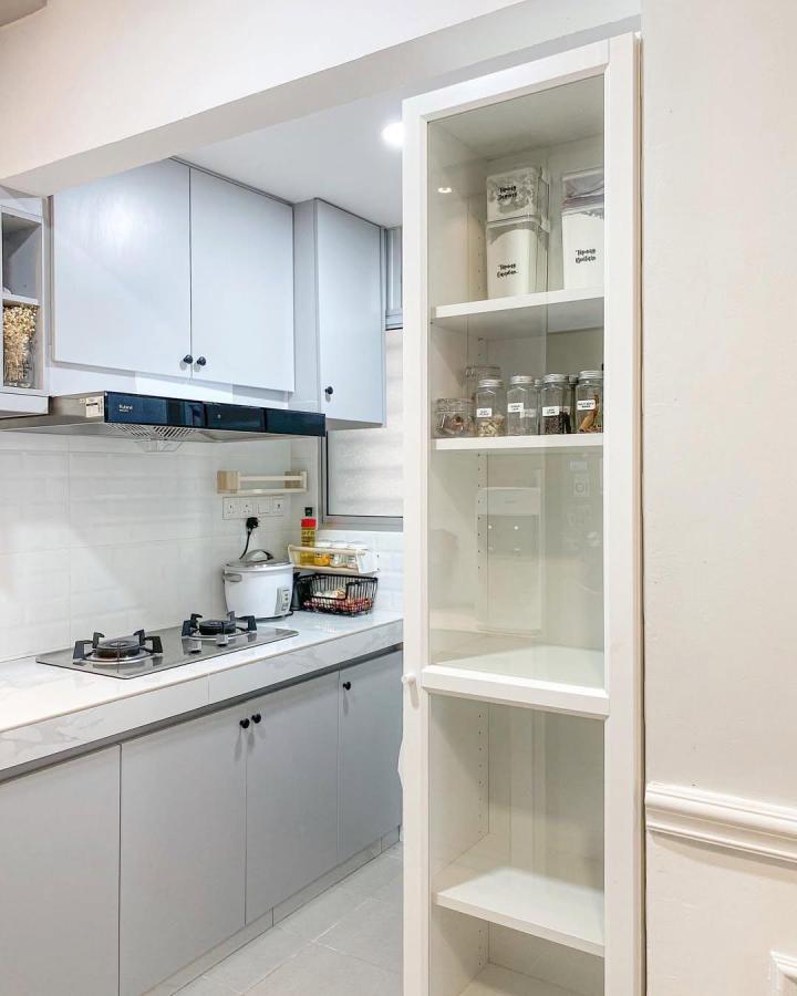 White glass door pantry cabinet from @decendana.home Kitchen storage with labeled jars and clean modern look.