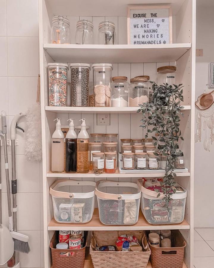 Clear glass jars with wood lids and textured baskets in white Ikea Billy pantry from @wawadels. Organized and cozy ikea billy pantry ideas.