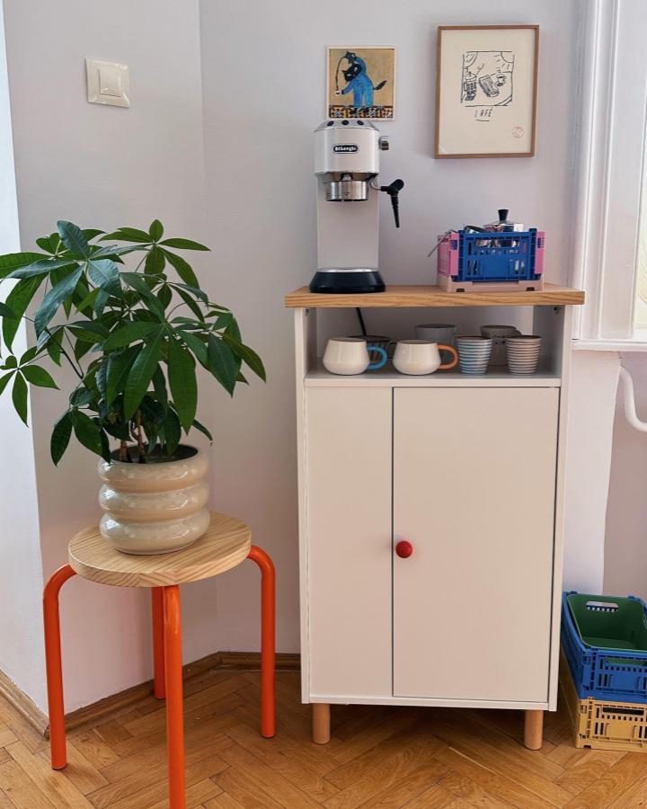 White BAGGEBO cabinet with wooden Besta panel, red knob, and espresso machine coffee nook by @mengmengliving. Cozy minimalist home coffee corner.