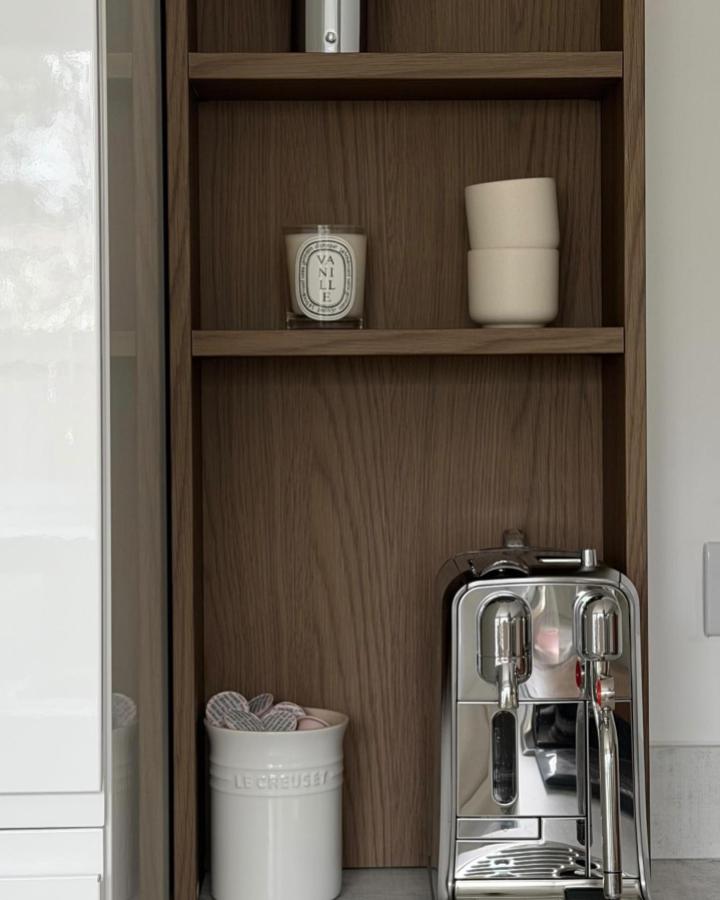 Warm wood HAGAÅN open cabinet coffee station from @counterproductivehome with chrome espresso machine and white ceramic mugs perfect ikea coffee station ideas.