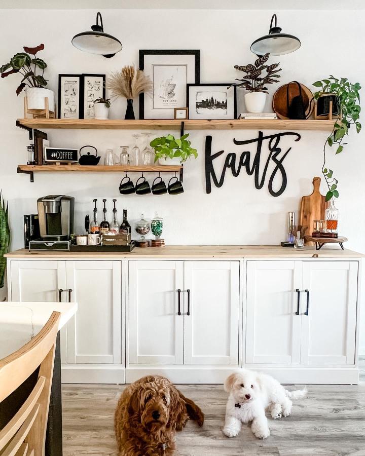 White farmhouse style coffee station with wood shelves and black metal accents from @our_kaatz_haus featuring IKEA HAVSTA cabinet and cozy décor.