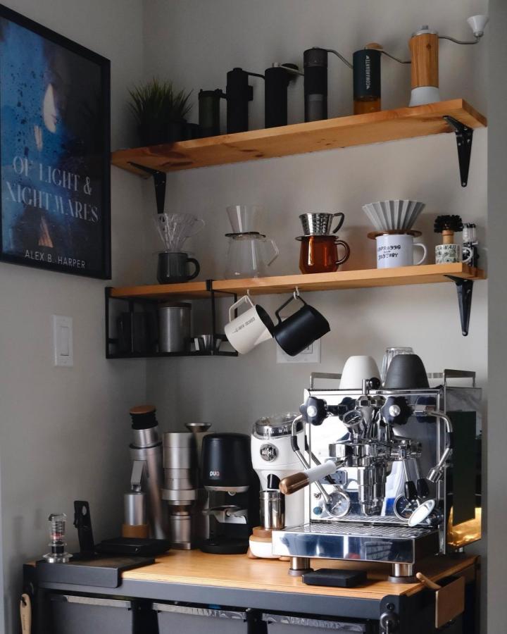 Light wood and black metal Ikea coffee corner setup from @bertofcoffee with espresso machine and pour-over accessories on a BROR cart and wall shelves.