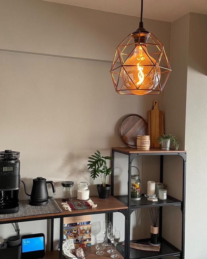 Black metal and wood shelving coffee nook from @m_i_room with warm lighting and cozy plant accents in compact space.