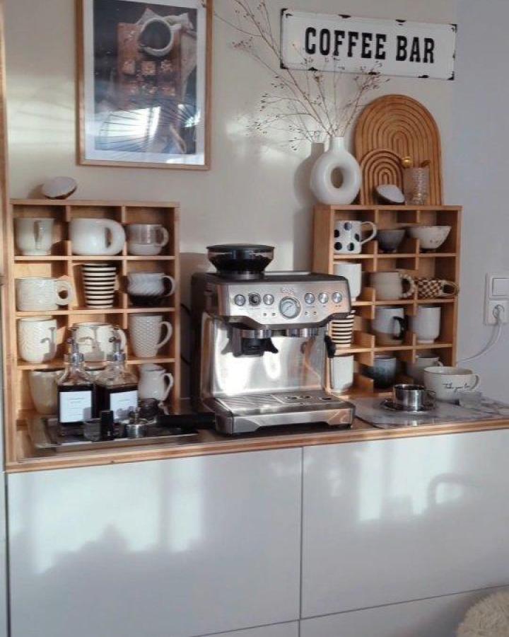 Light natural wood cubby shelves and silver espresso machine coffee station from @herzenstimme showing neat ikea coffee station ideas with organized mugs.