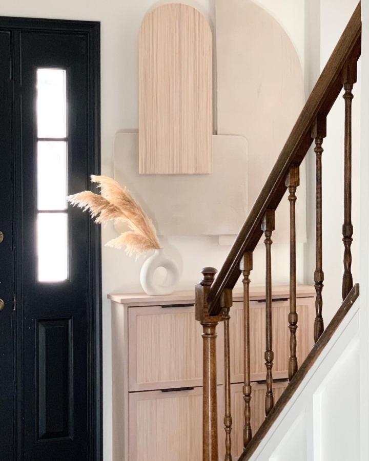 Light wood IKEA STÄLL entry cabinet and soft decor from @champagne.chaos with natural textures and black door contrast.