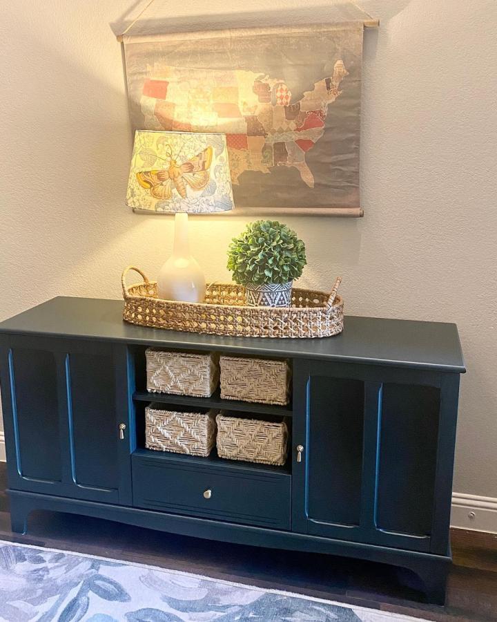 Deep navy IKEA LOMMARP cabinet with woven baskets and rattan tray from @alifemoreorganized brightening an entryway drop space.
