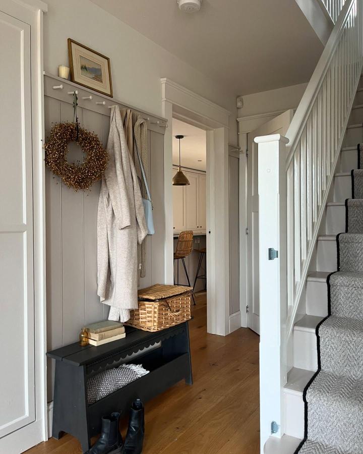 Cozy greige paneled entry with IKEA PERJOHAN hooks and black bench from @fourthhome_ showing smart ikea drop zone ideas.