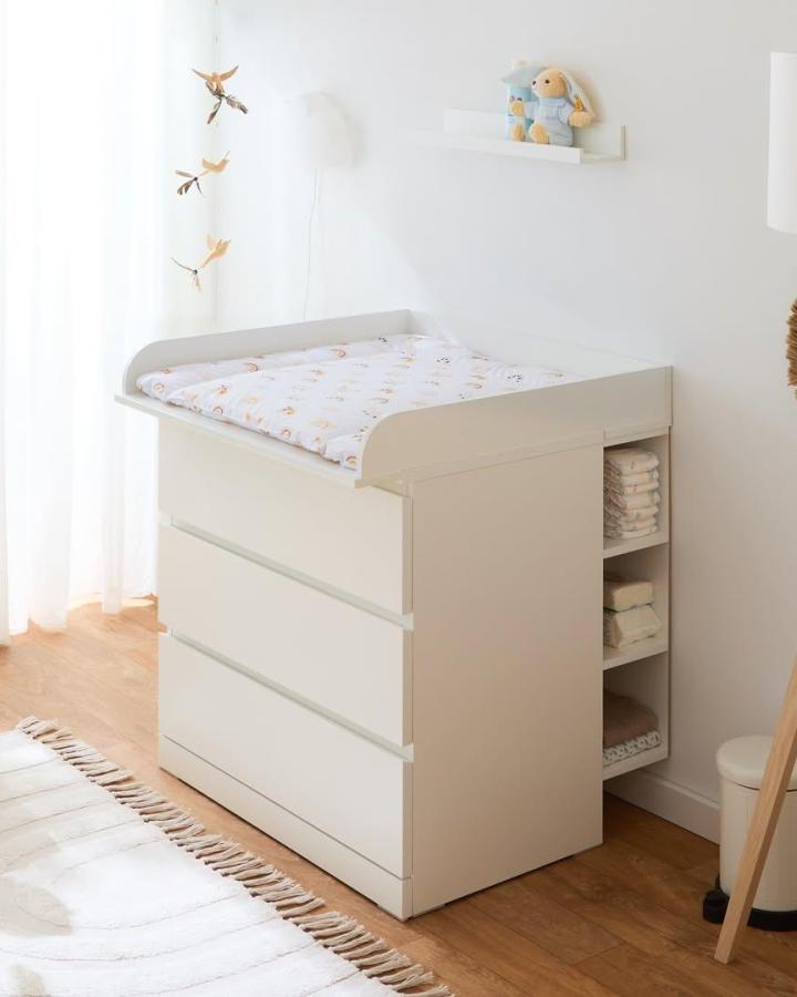White minimalist Malm-style changing table with built-in open shelving from @schwedenbaby.de. Practical nursery storage and soft natural lighting.