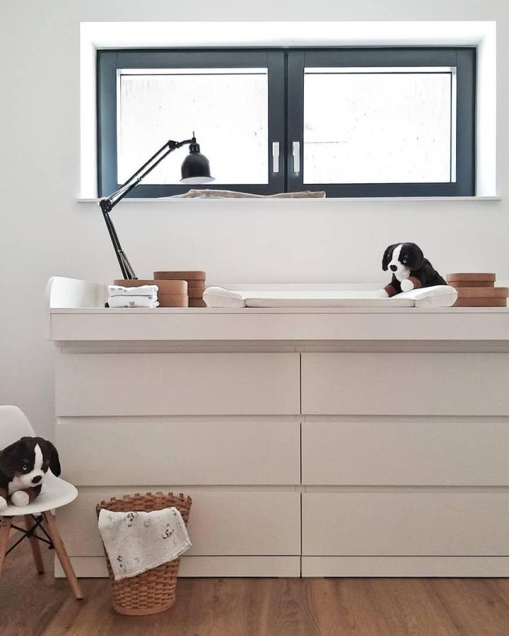 Beige Malm dresser as changing table with black lamp and woven basket from @petrakralj_ica. Minimalist and cozy nursery corner.