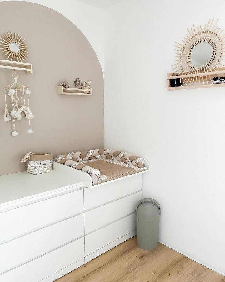 Beige and white Ikea Malm nursery setup from @carinamibu featuring soft braided changing pad and wooden shelves ikea malm nursery ideas.