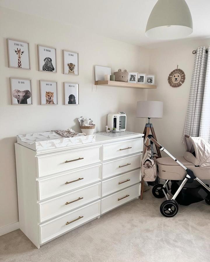 White wooden dresser with brass handles and neutral nursery decor from @ournewbuild_avalon. Stylish and functional baby storage setup.