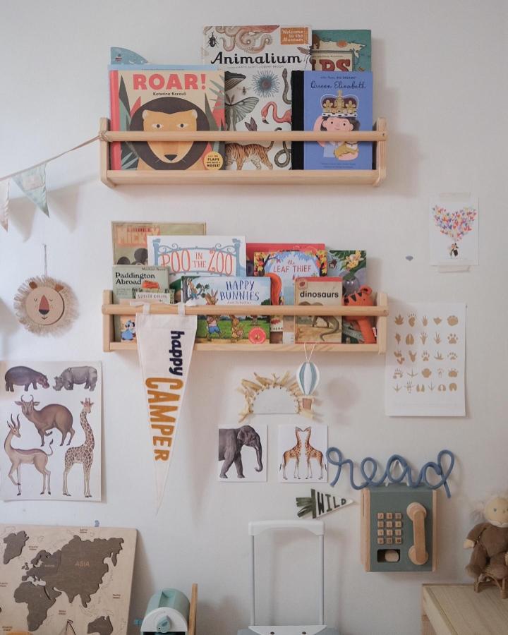 Light wood FLISAT shelves with colorful children's books and natural decor by @youmeandpea in a child-centered educational space.