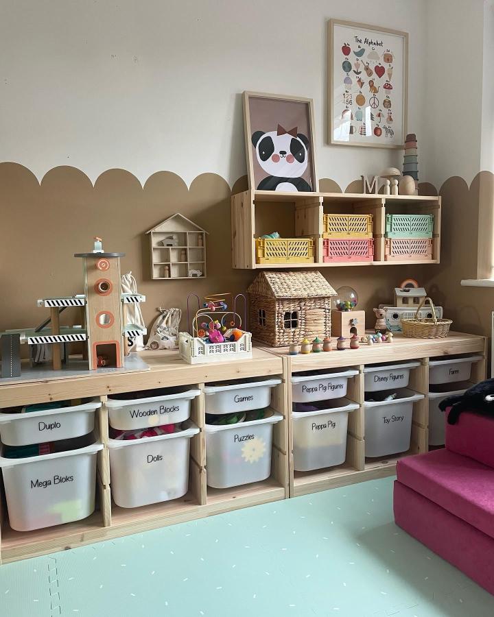 Natural wood Trofast storage with white bins and pastel crates from @life.with.madison.evie Cozy organized playroom with labeled toy storage and warm brown wall paint