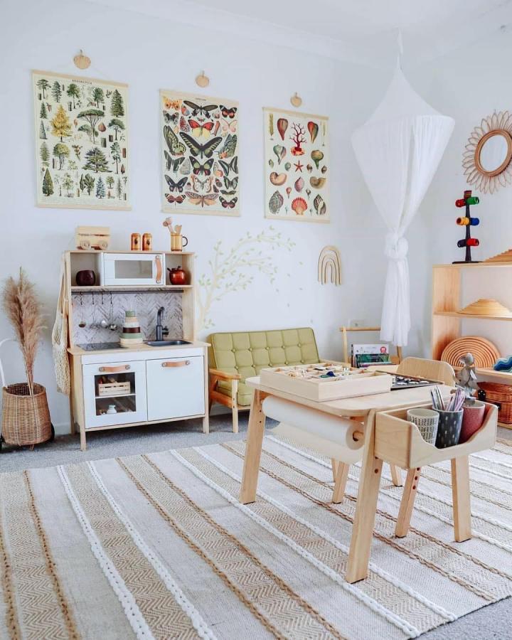 Natural wood play kitchen with green chair and nature prints from @honeyfur.montessori cozy creative kids space with learning zones.