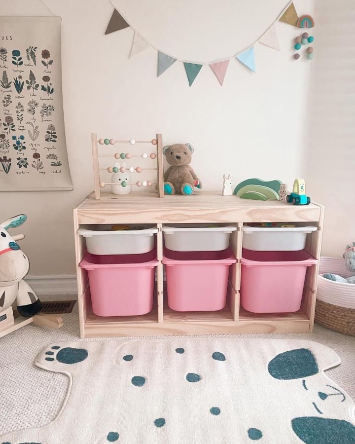 Pink and white IKEA TROFAST storage unit by @twinmumjen in a natural wood frame with pastel playroom accents and toys.