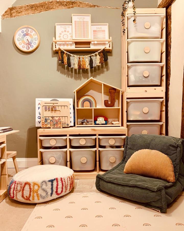 Natural pine wood TROFAST storage and FLISAT wall shelves from @ourmedievalcottage. Cozy, organized kids playroom inspired by Montessori principles.