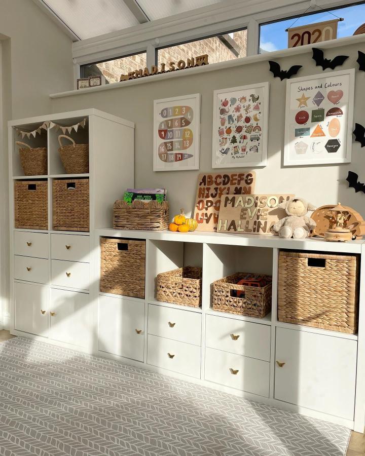 Neutral white Ikea Kallax shelving with woven LABBSAL baskets and natural wooden details in a Montessori-inspired playroom setup.