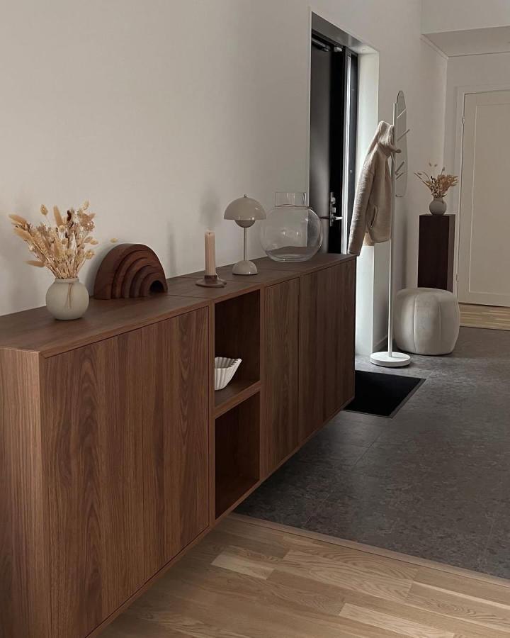 Walnut finish IKEA EKET cabinet with neutral décor from @wictorias.kvm. Cozy minimalist Scandinavian inspired storage idea.