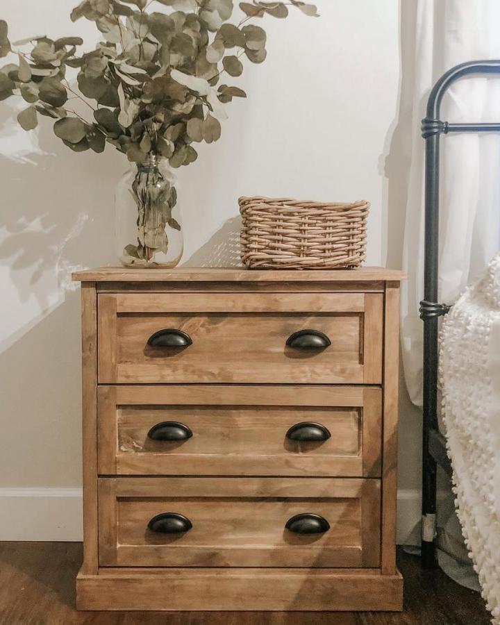 Natural stained wooden IKEA RAST drawers with black handles and woven decor by @brittkelleynelson showing cozy rustic furniture upgrade.