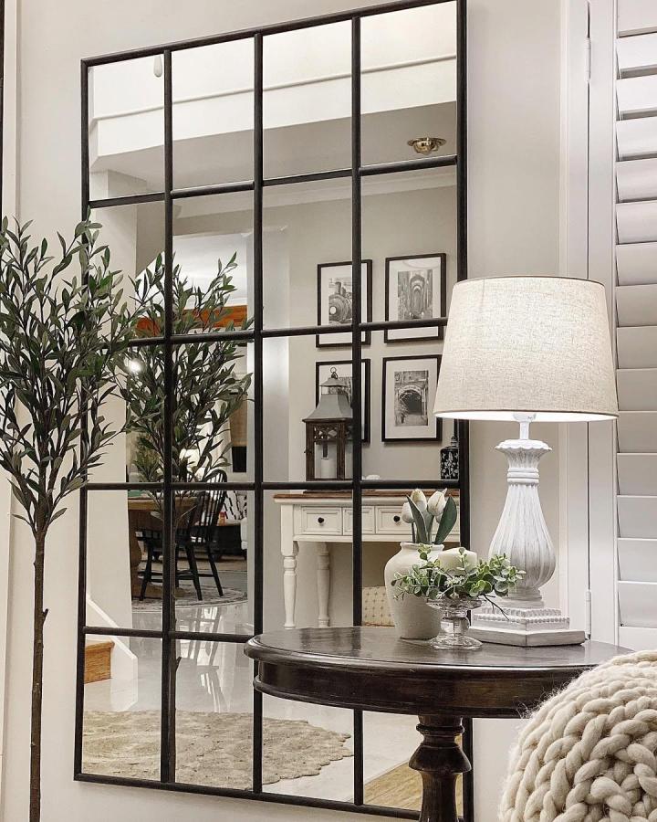 Black metal framed grid mirror in living room by @myhome_n_life Reflects light and adds a chic home accent inspired by pottery barn style