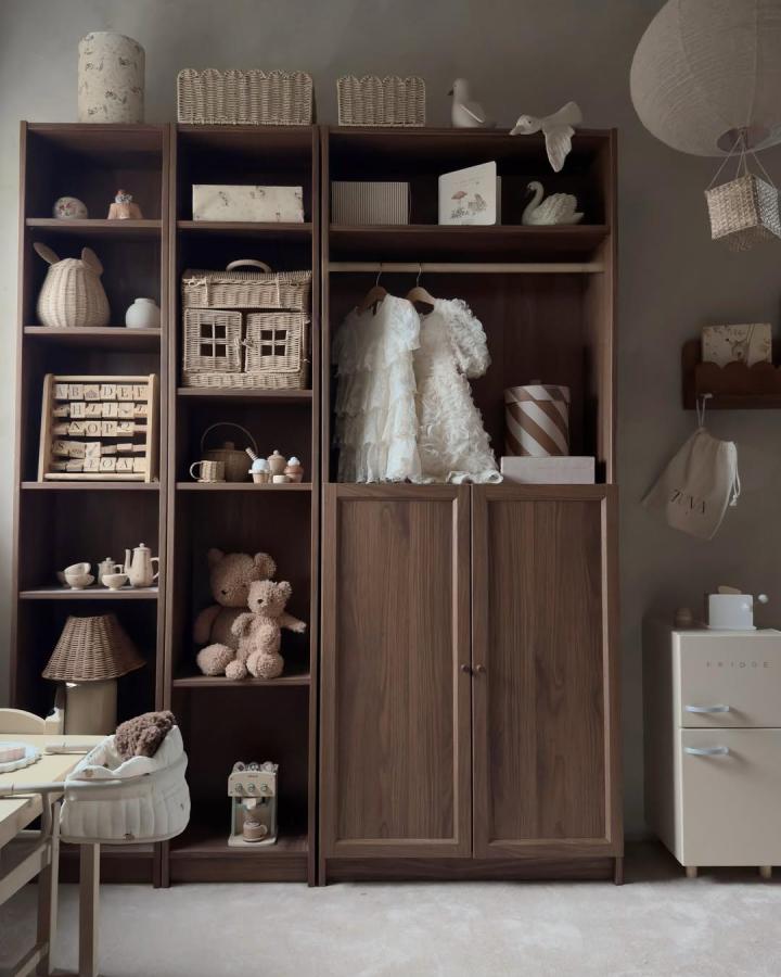 Warm walnut built-in style storage using Ikea Billy and Oxberg units by @rebfre with wicker baskets and cozy kids decor.