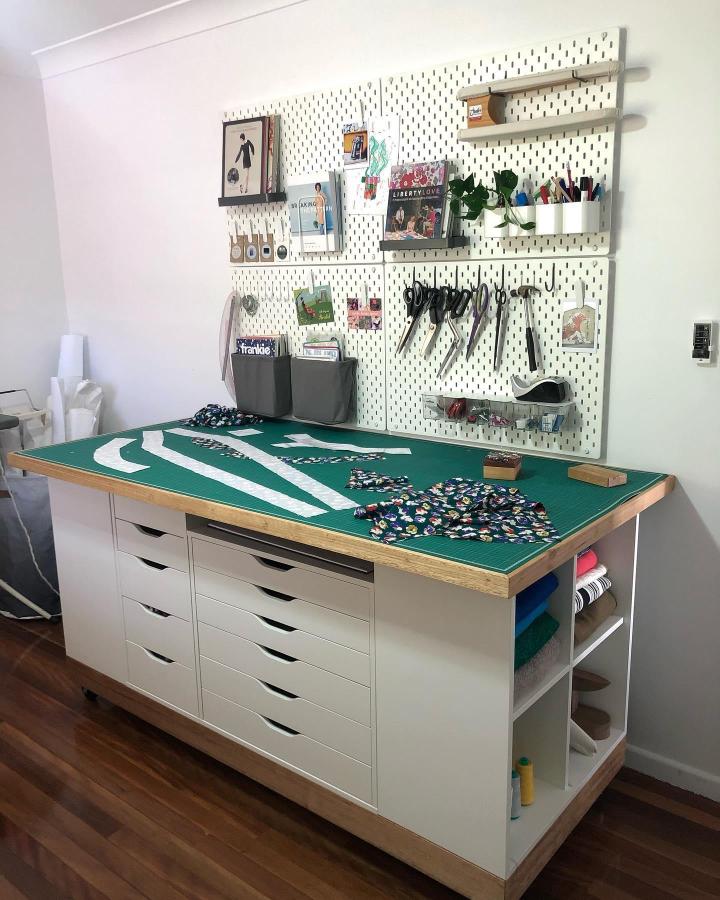 White Alex drawer sewing island with Kallax base and pegboard wall by @rhubarbsundays Fabric cutting and tool storage setup with clean lines and natural wood accents