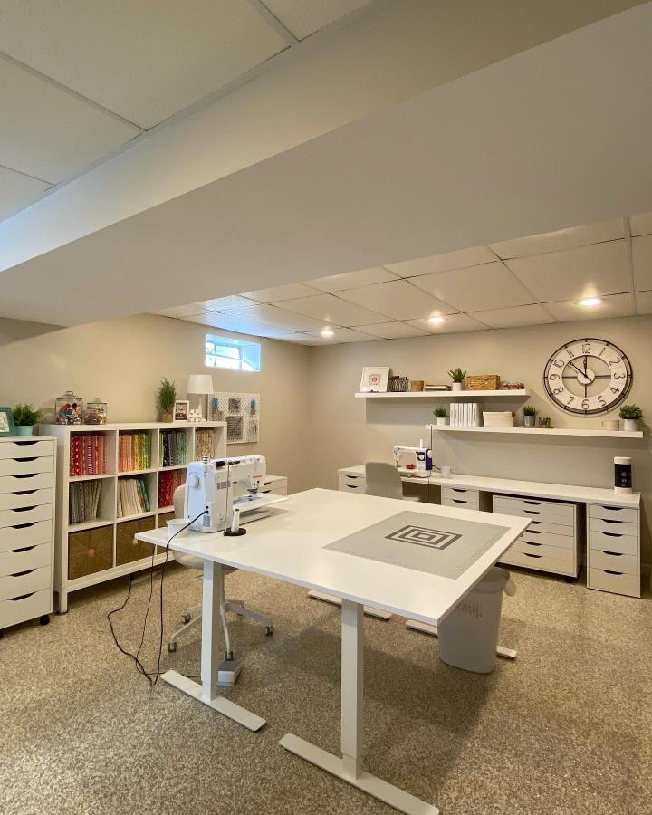 Bright white Ikea sewing table ideas room by @tawnya_gram showing Kallax shelves and Bekant desk with neat fabric storage.