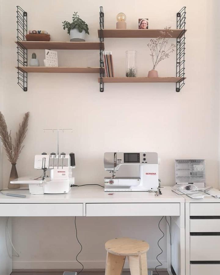 White and wood sewing workspace with IKEA MICKE desk and shelves from @wisj_sofie. Clean, organized, and minimal sewing setup.