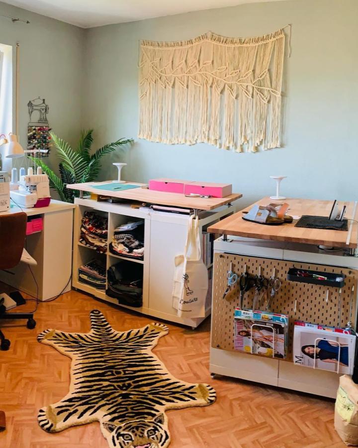 Natural wood Ikea Kallax sewing room with neutral decor and pink accents by @sewwiesew functional crafting area with pegboard and fabric storage.