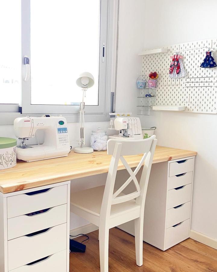White minimalist sewing nook with twin Ikea Alex drawer units and natural wood tabletop from @artdollhouse_ bright and tidy craft space with pegboard organization