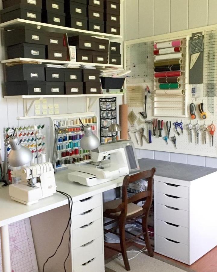 White Ikea Linmon tabletop sewing station with Alex drawer cabinets and pegboard tool organizer by @agvsews. Organized craft room with neat storage solutions.