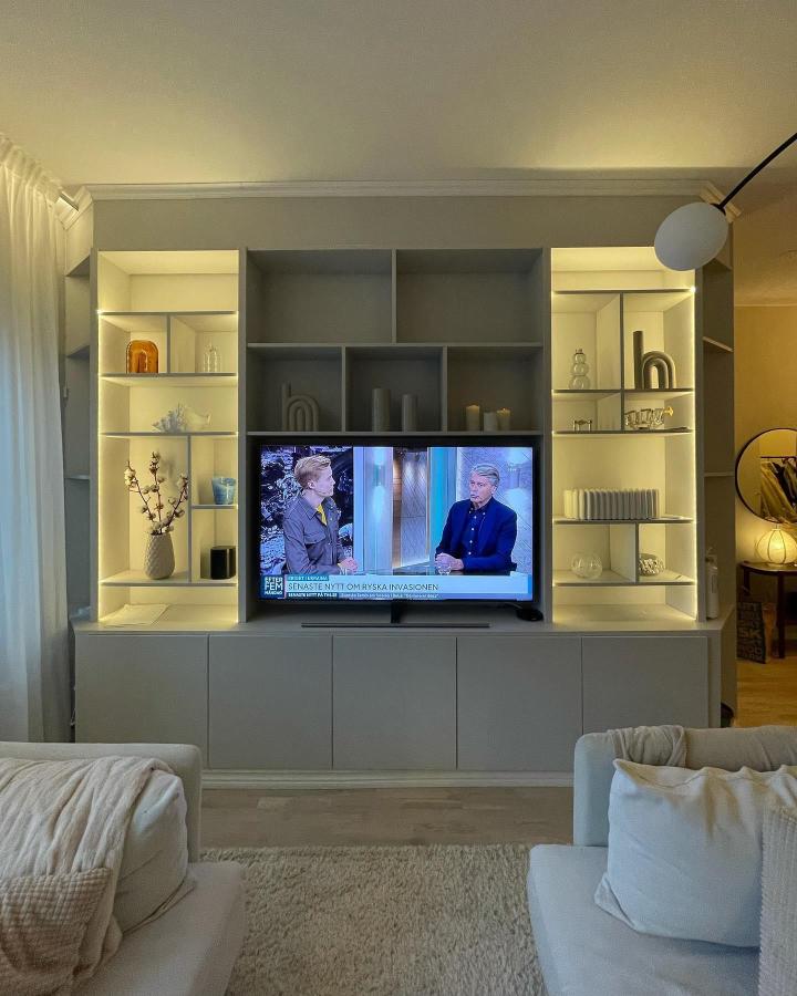 Gray built-in lit Billy bookcase and Besta units from @villadelaval showing ikea small living room hacks with cozy lighting and organized shelves.