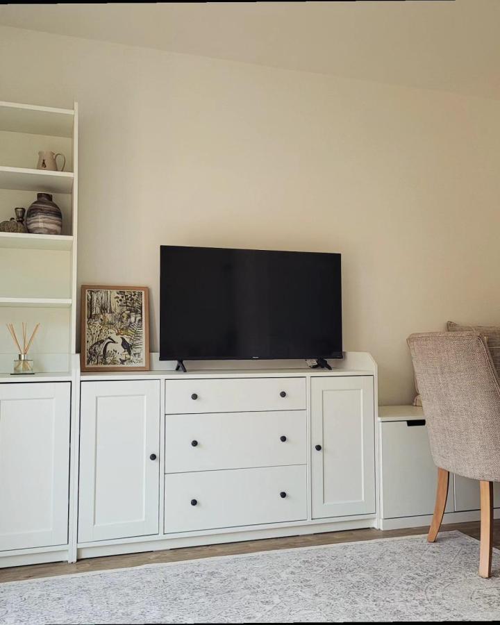 White Nordli and Hauga furniture media console by @ourlittle_place in a cozy neutral living room stylishly maximizing compact space.
